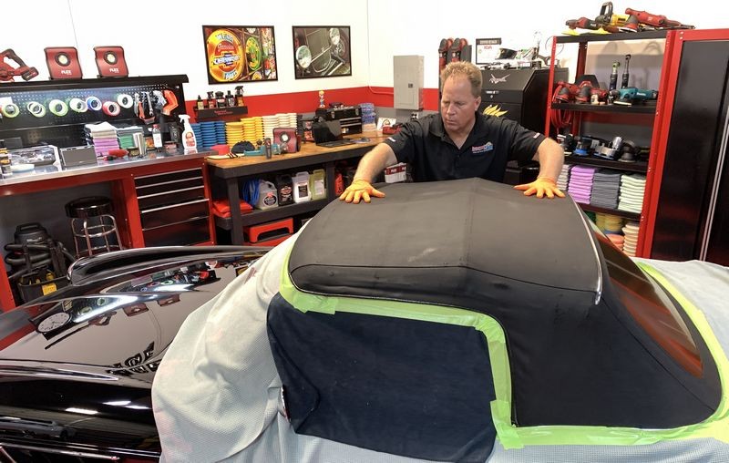 Rubbing RaggTopp Fabric Protectant into convertible top